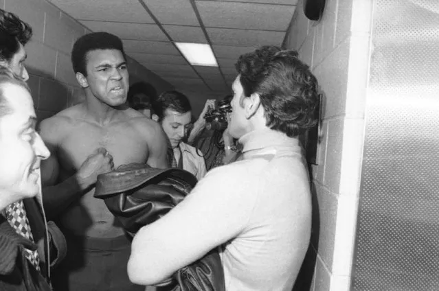 Muhammad Ali scowls at Argentinean Oscar Bonavena in corridor at Madison Square Garden in New York on December 1, 1970. They appeared at the Garden for a pre-fight physical examination. They'll meet on December 7 in a 15-round heavyweight bout. They engaged in a shoving and shouting match after undergoing their physicals, following up this confrontation before the exam. (Photo by Harry Harris/AP Photo)