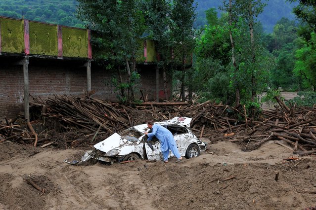 Gul Rasheed, 60, inspects a damaged car following a storm that caused heavy rains and flooding, in Bayshonai Kalay, Buner district, Khyber Pakhtunkhwa province, Pakistan, on August 17, 2025. (Photo by Akhtar Soomro/Reuters)