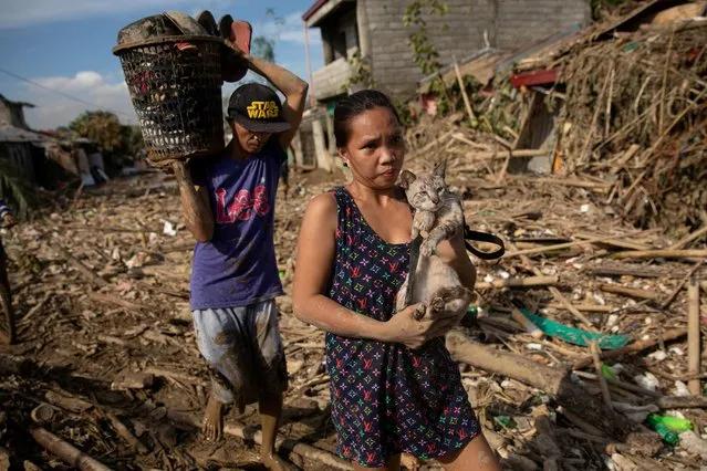 A woman retrieves her cat from a submerged village following floods caused by Typhoon Vamco, in Rodriguez, Rizal province, Philippines, November 14, 2020. (Photo by Eloisa Lopez/Reuters)