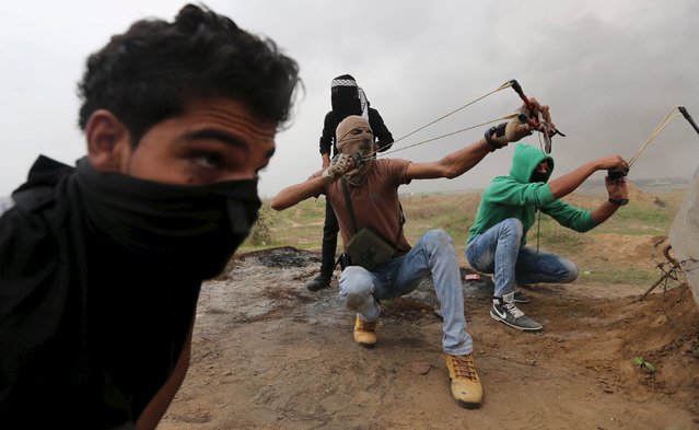 Palestinian protesters use sling shot to hurl stones at Israeli troops during clashes near border between Israel and Central Gaza Strip November 6, 2015. Eleven Israelis have been killed in stabbings, shootings or other attacks. At least 69 Palestinians have been shot dead by Israeli forces, including 42 who Israel says were attackers. (Photo by Ibraheem Abu Mustafa/Reuters)