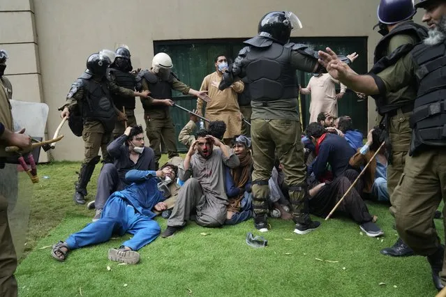 Police  detain supporters of former Prime Minister Imran Khan during a search operation in the Khan's resident, in Lahore, Pakistan, March 18, 2023. (Photo by K.M. Chaudary/AP Photo)