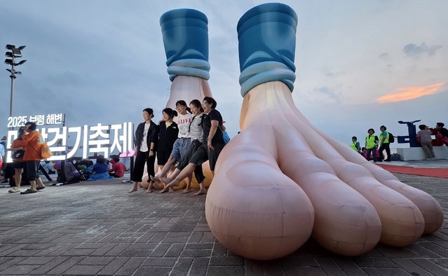 Participants in the “Beach Barefoot Walking Festival” held at Daecheon Beach in Boryeong, South Chungcheong Province on the afternoon of the September 6, 2025 are taking a commemorative photo in front of a sculpture symbolizing the festival. (Photo by Shin Hyeon-jong)