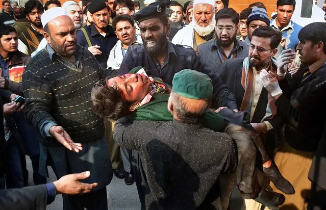 Hospital security guards carry a students injured in the shootout at a school under attacked by Taliban gunmen in Peshawar, Pakistan,Tuesday, December 16, 2014. Taliban gunmen stormed a military school in the northwestern Pakistani city, killing and wounding dozens, officials said, in the latest militant violence to hit the already troubled region. (Photo by Mohammad Sajjad/AP Photo)