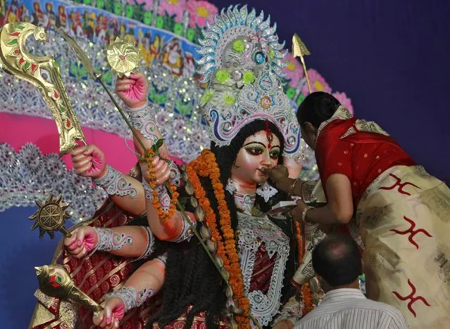 A devotee offers sweets to an idol of the Hindu goddess Durga while offering prayers on the last day of the Durga Puja festival in Allahabad, India, October 23, 2015. The Durga Puja festival is the biggest religious event for Bengali Hindus. Hindus believe that the goddess Durga symbolises power and the triumph of good over evil. (Photo by Jitendra Prakash/Reuters)