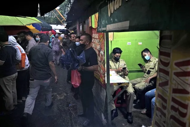 Men wait for the time to break their fast at a food stall, during the first week of the holy fasting month of Ramadan, in Jakarta, Indonesia, Saturday, March 25, 2023. Muslims around the world are observing Ramadan, the holiest month in Islamic calendar, where they refrain from eating, drinking, smoking, and s*x from dawn to dusk. (Photo by Dita Alangkara/AP Photo)