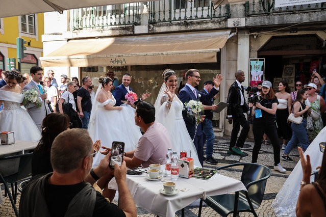 Newly-wed couples parade through the streets after they got married during a traditional ceremony, dubbed the “Weddings of 'St. Anthony” at the Cathedral of Lisbon, in Lisbon, Portugal, 12 June 2024. Eleven couples got married this time during the traditional event which refers to the 12th century Saint Anthony of Padua who was born in Lisbon and is considered a matchmaker and patron of young brides. The “Weddings of St. Anthony” tradition dating from 1958 is part of the Lisboa festivities and was meant as a way of giving couples in financial difficulties the opportunity to get married. (Photo by Joao Relvas/EPA)