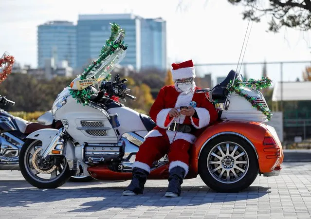 A man dressed in Santa Claus costume wearing a protective face mask pauses before Xmas Toy Run parade to rev up the holiday spirit and rally against child abuse, organised by Harley Santa Club, amid the coronavirus disease (COVID-19) outbreak, in Tokyo, Japan on December 20, 2020. (Photo by Issei Kato/Reuters)