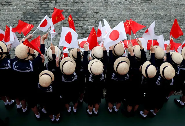 Kindergarten pupils wave national flags as Chinese Premier Li Keqiang reviews the guard of honour with Japan's Prime Minister Shinzo Abe during a welcoming ceremony before their bilateral talks at Akasaka Palace state guest house in Tokyo, Japan May 9, 2018. (Photo by Toru Hanai/Reuters)