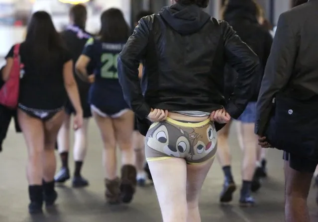 A participant adjusts her underwear during the annual No Pants Light Rail Ride organized by the Emerald City Improv group in Seattle, Washington January 11, 2015. (Photo by Jason Redmond/Reuters)
