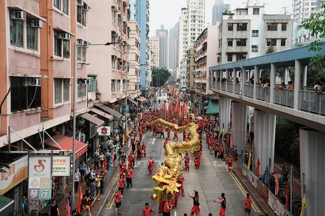 Participants march with a golden dragon during a parade celebrating Tin Hau festival at Yuen Long district, in Hong Kong, China on May 12, 2023. (Photo by Lam Yik/Reuters)