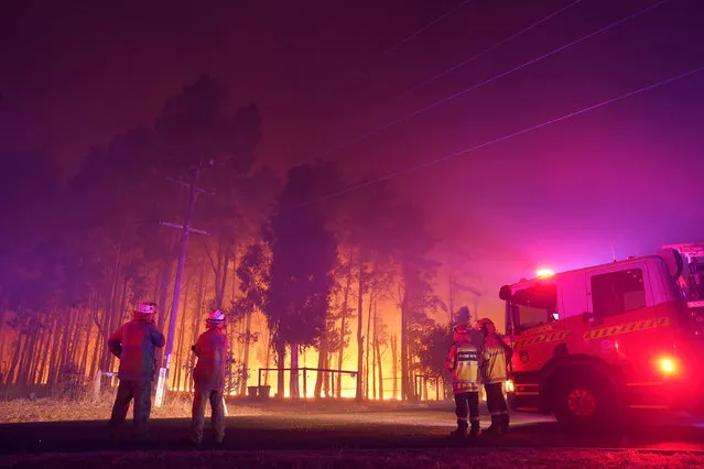 Firefighters attend a fire at Wooroloo, near Perth, Australia, Monday, February 1, 2021. An out-of-control wildfire burning northeast of the Australian west coast city of Perth has destroyed an estimated 30 homes and was threatening more Tuesday, with many locals across the region told it is too late to leave. (Photo by Evan Collis/DFES via AP Photo)