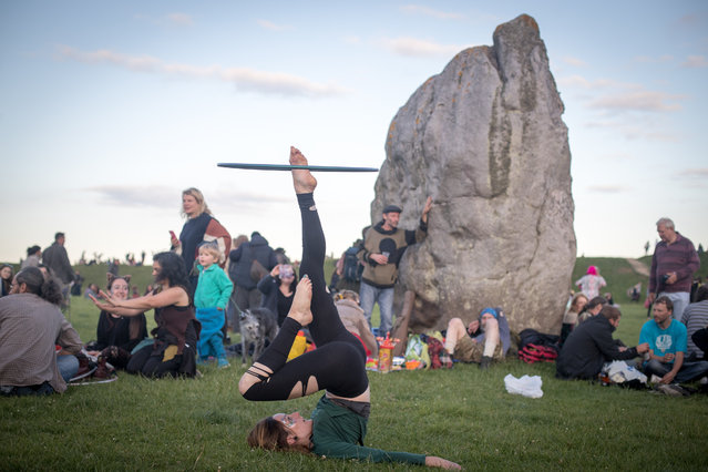 A woman practise yoga at Avebury Neolithic henge monument, a UNESCO World Heritage site, as the sun begins to set on June 20, 2018 in Wiltshire, England. (Photo by Matt Cardy/Getty Images)