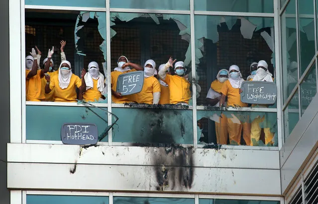 Inmates yell from broken windows at the St. Louis Justice Center, known as the city jail, on Saturday, February 6, 2021 in St. Louis, Mo. Firefighters are at the jail where inmates appear to have knocked out windows and set some small fires. A spokesman for Mayor Lyda Krewson said there was “an ongoing and very dangerous disturbance” going on at the St. Louis City Justice Center on Saturday morning. (Photo by Robert Cohen/St. Louis Post-Dispatch via AP Photo)