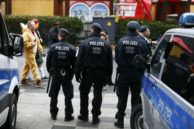 Revellers walk past police to celebrate the start of the carnival season, a season of controlled raucous fun that reaches a climax during the days before Ash Wednesday and the start of Lent, at 11.11 am in Cologne, Germany, November 11, 2016. (Photo by Wolfgang Rattay/Reuters)