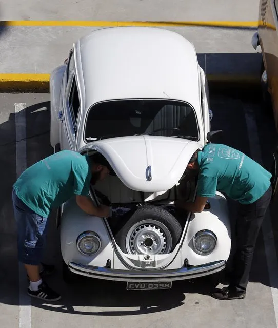 Visitors check a Volkswagen beetle during a Volkswagen Beetle owners' meeting in Sao Bernardo do Campo January 25, 2015. (Photo by Paulo Whitaker/Reuters)