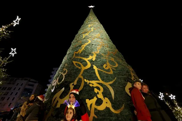 Residents take pictures in front of a decorated Christmas tree in Beirut, Lebanon, December 12, 2015. (Photo by Jamal Saidi/Reuters)