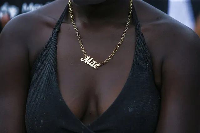 A woman wearing a necklace with the word "Mother" in Portuguese, protests against the killing of Emily Victoria Silva dos Santos, 4, and Rebeca Beatriz Rodrigues dos Santos, 7, in Duque de Caxias, Rio de Janeiro state, Brazil, Sunday, December 6, 2020. The girls, cousins, were killed by stray bullets while playing outside their homes. (Photo by Bruna Prado/AP Photo)