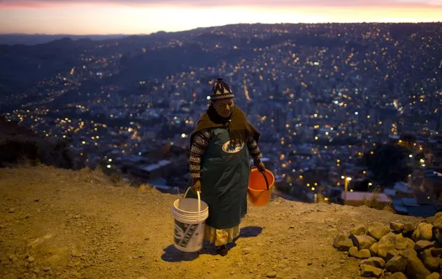 A woman walks with two buckets to wait for a water bowser to arrive near her neighborhood in La Paz, Bolivia, Wednesday, November 16, 2016. Bolivia's President Evo Morales asks for forgiveness from La Paz residents for the water shortages caused by the worst drought in 25 years and acknowledged that there will be no immediate solutions. (Photo by Juan Karita/AP Photo)