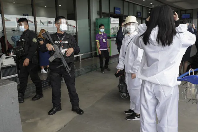 A policeman reminds passengers to wear their face shields properly at Manila's International Airport, Philippines, Monday, January 18, 2021. (Photo by Aaron Favila/AP Photo)