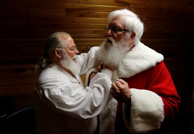 Santa Jim Hastings (R) from Durham, North Carolina, is helped into his suit by a fellow Santa prior to a visit from a group of children at the Santa House in Midland, Michigan, U.S. October 28, 2016. (Photo by Christinne Muschi/Reuters)