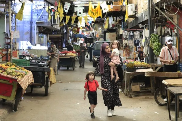 A Palestinian woman with her kids walks down a street, in Ein el-Hilweh Palestinian refugee camp, in the southern port city of Sidon, Lebanon, Tuesday, June 20, 2023. (Photo by Mohammed Zaatari/AP Photo)