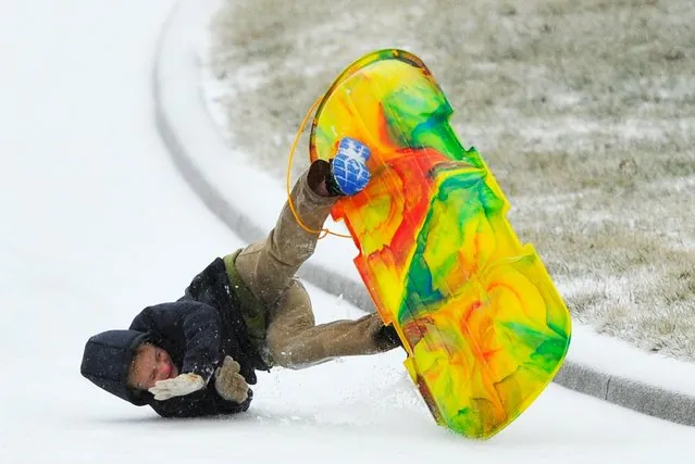 Nathan Moser flips as he sleds down an icy street covered by a winter storm that hit the Southeastern USA Monday, February 16, 2015 in Brentwood, Tennessee. (Photo by Harrison McClary/Reuters)