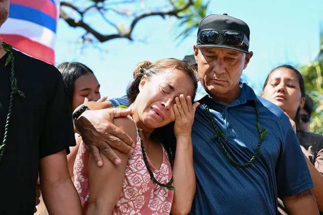 Tiare Lawrence is comforted by Archie Kalepa as community members hold a press conference at Wahikuli Beach Park to address issues concerning the fire in Lahaina on Friday August 18, 2023 in Lahania, HI. The death toll continues to rise for the fires on Maui. (Photo by Matt McClain/The Washington Post)