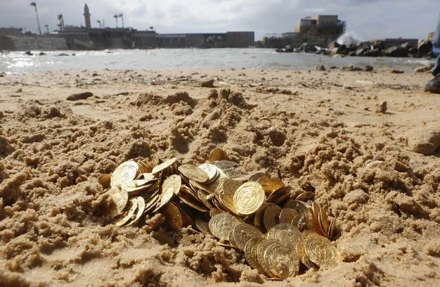 Ancient gold coins are displayed in Caesarea, north of Tel Aviv along the Mediterranean coast February 18, 2015. Almost 2,000 gold coins, believed to be from the 11th century, were found in recent weeks on the seabed by amateur divers who then alerted the Israel Antiquities Authority's Marine Archaeology Unit. (Photo by Nir Elias/Reuters)