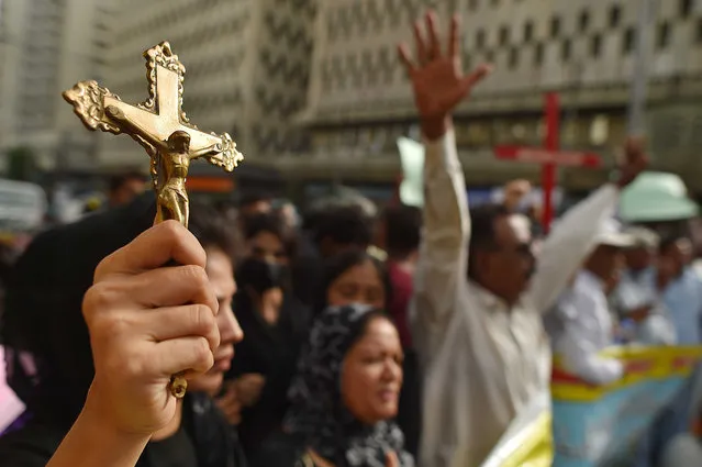 A member of the Christian community holds up a cross during a protest against Faisalabad violence incidents, in Karachi, Pakistan, 17 August 2023. Armed mobs in Jaranwala targeted two churches and private homes, setting them on fire and causing widespread destruction. The attack was sparked by the discovery of torn pages of the Muslims holy book Koran with alleged blasphemous content near a Christian colony. (Photo by Shahzaib Akber/EPA/EFE)