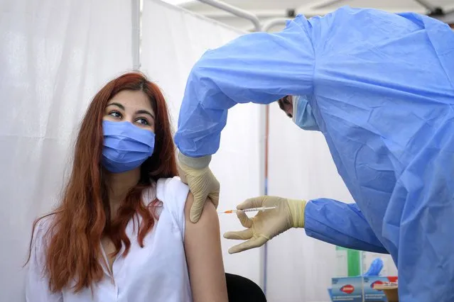 A girl gets a Pfizer BioNTech COVID-19 vaccine in Bucharest, Romania, Wednesday, June 2, 2021. Romania has started the vaccination campaign for children between the ages of 12 and 15. (Photo by Andreea Alexandru/AP Photo)