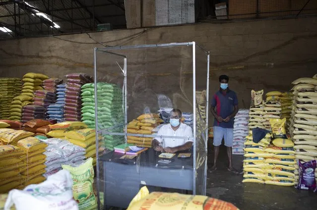 A Sri Lankan trader waits for customers adhering to health guidelines given by the authorities to curb the spread of coronavirus at a wholesale market in Welisara, outskirts of Colombo, Sri Lanka, Monday, May 31, 2021. (Photo by Eranga Jayawarden/AP Photo)