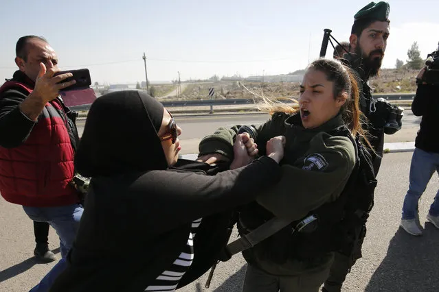 A protestor scuffles with an Israeli boder guard during a demonstration by Palestinian, Israeli and foreign protesters against the newly-opened Route 4370, on January 23, 2019, in the occupied West Bank. The highway into Jerusalem divides Israeli and Palestinian drivers into separate lanes with a wall, leading Palestinians to label it an “apartheid road”. Its western side serves Palestinians, who cannot enter Jerusalem, whereas the road’s eastern side serves settlers, who can now reach northern Jerusalem. (Photo by Abbas Momani/AFP Photo)