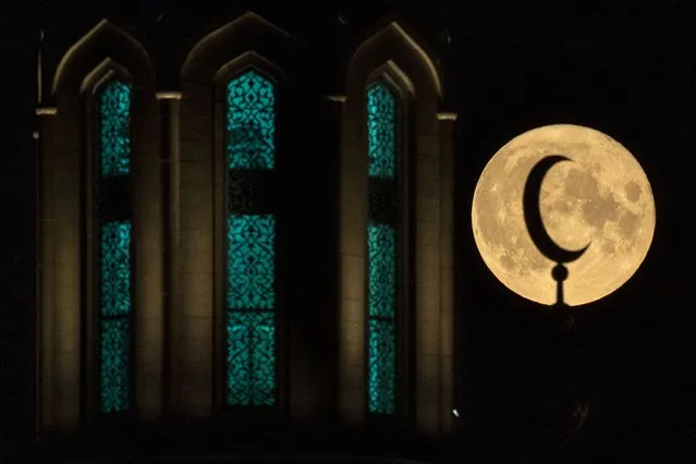 A full moon behind the Sobornaya, Moscow Cathedral Mosque in Moscow, on August 22, 2021. (Photo by Kirill Kudryavtsev/AFP Photo)