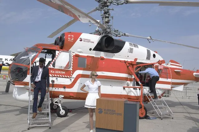 An attendant stands by a Russian Helicopters' KA-32 helicopter at the Dubai Air Show in Dubai, United Arab Emirates, Wednesday, November 15, 2023. (Photo by Jon Gambrell/AP Photo)