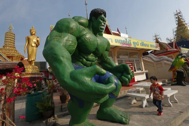 A boy walks beside a statue of comic character the Hulk at Tamru temple in Samut Prakan province, Thailand, March 3, 2016. (Photo by Chaiwat Subprasom/Reuters)