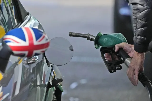 A driver fills a car with fuel at a petrol station in London, Wednesday, September 29, 2021. Prime Minister Boris Johnson sought to reassure the British public Tuesday that a fuel-supply crisis snarling the country was “stabilizing”, though his government said it would be a while before the situation returns to normal. Johnson's government has put army troops on standby to help distribute gasoline and help ease a fuel drought, triggered by a shortage of truck drivers, that has drained hundreds of pumps and sent frustrated drivers on long searches for gas. (Photo by Frank Augstein/AP Photo)