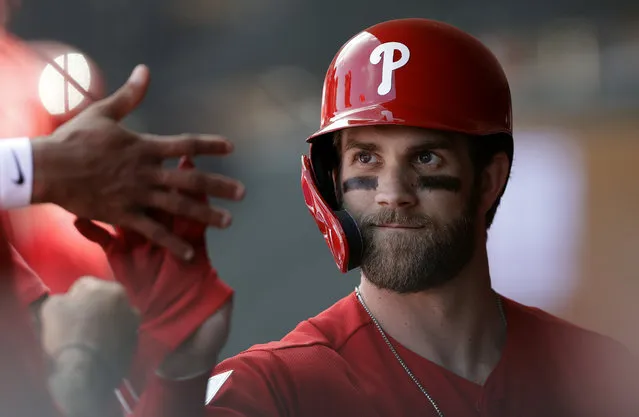 Philadelphia Phillies' Bryce Harper high-fives teammates after being taken out during the third inning of a spring training baseball game against the Toronto Blue Jays, Saturday, March 9, 2019, in Clearwater, Fla. ({hoto by Chris O'Meara/AP Photo)