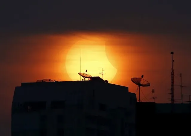 A partial solar eclipse is seen next to a building in Bangkok, Thailand, 09 March 2016. A partial solar eclipse will be visible in several southseast Asian countries, including Vietnam, the Philippines, Myanmar and Cambodia. A total solar eclipse will be visible in Indonesia and in the central Pacific region. (Photo by Rungroj Yongrit/EPA)