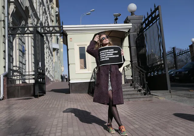 A human rights activist holds a poster as she pickets Russian President's Administration building in Moscow, Russia on Thursday, March 10. 2016. The Committee to Protect Journalists is blaming Russian authorities’ inattention to anti-media hostility as enabling the attack near Chechnya that left six journalists injured. The CPJ’s statement Thursday came a day after attackers intercepted a small bus carrying activists and journalists, beat them and set the vehicle afire. (Photo by Ivan Sekretarev/AP Photo)