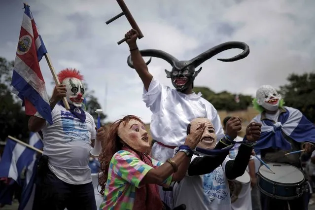 Two people with masks that represent the President of Nicaragua, Daniel Ortega and his wife, Vice President Rosario Murillo in handcuffs, during a protest through the main streets of San Jose against the presidential elections in their country of Nicaragua, in San Jose, Costa Rica, 07 November 2021. The protestors are against what they believe to be “fraud” and the electoral “circus” orchestrated by the President of Nicaragua Daniel Ortega. Several Nicaraguan opposition groups united around the world to repudiate the elections that were held in their country. (Photo by Jeffrey Arguedas/EPA/EFE)