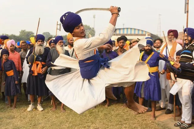 A Nihang' or Sikh warrior performs “Gatka”, an ancient form of Sikh martial arts, during a Fateh Divas celebration a day after the Hindu festival Diwali, in Amritsar on November 5, 2021. (Photo by Narinder Nanu/AFP Photo)