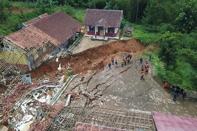 This photo shows an aerial view of members of the West Java Regional Disaster Management Agency inspecting a school destroyed by a landslide after heavy rains in Bandung, West Java, on March 4, 2024. (Photo by Timur Matahari/AFP Photo)