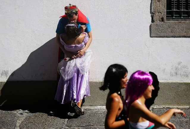 A couple in costume kiss during the Boitata block party, a pre-Carnival celebration in Rio de Janeiro, February 23, 2014. (Photo by Leo Correa/Associated Press)