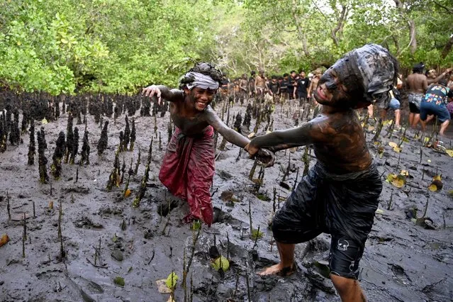 Balinese people take part in a mud bath tradition, known as Mebuug-buugan, held a day after Nyepi – the Balinese “Day of Silence” – aimed at neutralising bad traits, in the village of Kedonganan, on Indonesia's resort island of Bali on March 12, 2024. (Photo by Sonny Tumbelaka/AFP Photo)
