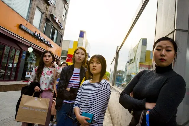 Women stand outside an upmarket boutique for its opening in the fashion district of Apgujeong in Seoul, May 7, 2015. (Photo by Thomas Peter/Reuters)