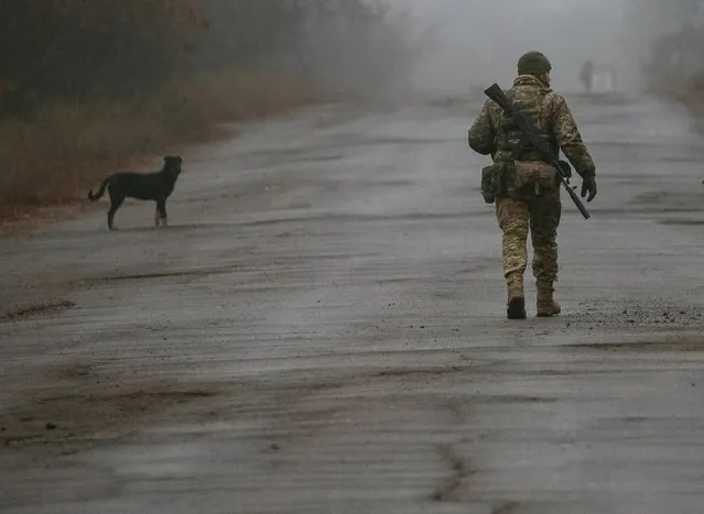 A Ukrainian serviceman walks along a street near the front line in the village of Travneve in Donetsk region, Ukraine, December 15, 2021. (Photo by Gleb Garanich/Reuters)