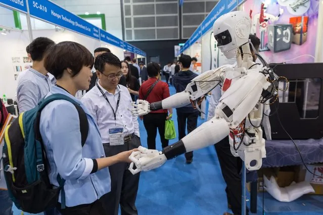 Visitors look at a humanoid 3D-print robot during the spring edition of the Hong Kong Electronics Fair in Hong Kong, China, 13 April 2016. The different parts of the robot were made on a 3D printer with an open source software. The robot can do gesture capture, 3D depth recognition and presence detection. The fair features over 3000 exhibitors from 24 countries and runs through 16 April. (Photo by Jerome Favre/AFP Photo)