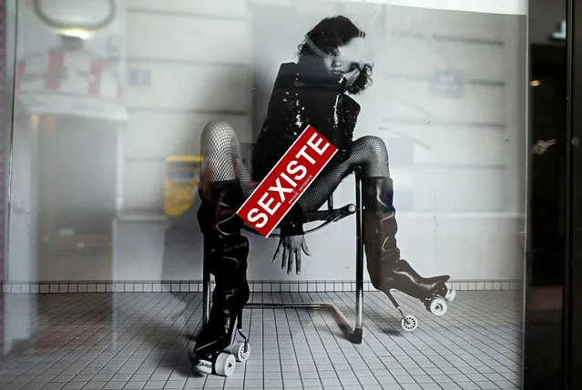 A sticker which reads “sеxist” is seen on an ad by French fashion house Yves Saint Laurent displayed on a newspaper kiosk in Paris, France, March 6, 2017. France's advertising watchdog on Monday said it had asked French fashion house Yves Saint Laurent to modify two ads from its latest campaign after receiving 50 complaints that they were “degrading” to women. (Photo by Charles Platiau/Reuters)