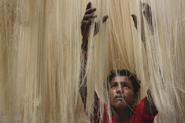 An Indian worker dries vermicelli, used to make a traditional sweet dish popular during the Islamic holy month of Ramadan, in Hyderabad, India, Thursday, June 25, 2015. Muslims throughout the world are marking the month of Ramadan, the holiest month in the Islamic calendar during which devotees fast from dawn till dusk. (Photo by Mahesh Kumar A./AP Photo)