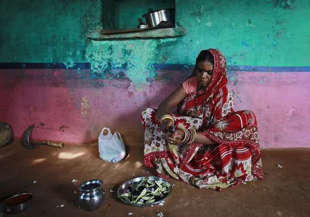 Krishna, 13, cuts vegetables inside the kitchen at her house in a village near Baran, located in Rajasthan, July 17, 2012. (Photo by Danish Siddiqui/Reuters)
